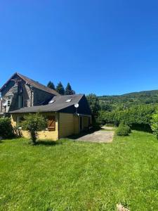 une maison dans un champ d'herbe verte dans l'établissement Maison lumineuse et spacieuse avec terrain, à La Bourboule