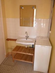 La salle de bains est pourvue d'un lavabo et d'un miroir. dans l'établissement Maison lumineuse et spacieuse avec terrain, à La Bourboule