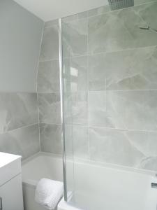 a shower with a glass door in a bathroom at Woldsend in Moreton in Marsh