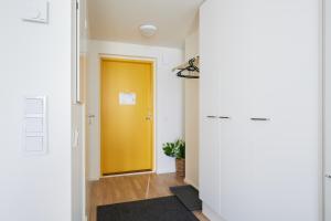 un pasillo con una puerta amarilla en Keskeisen sijainnin uudiskohde, Seamless check-in, Baby crib, en Turku 1 foto más