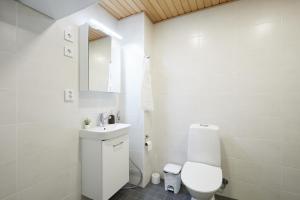 Un baño blanco con inodoro y lavabo. en Keskeisen sijainnin uudiskohde, Seamless check-in, Baby crib, en Turku