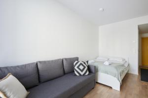 una sala de estar con un sofá y una cama en Keskeisen sijainnin uudiskohde, Seamless check-in, Baby crib, en Turku