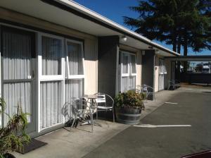 ヘイスティングズにあるCamberley Court Motelの椅子、テーブル、窓のある建物