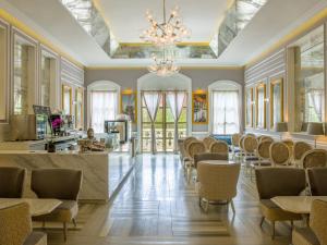 a dining room with chairs and a bar with a chandelier at Fiesta Americana Merida in Mérida