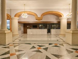an empty lobby with columns and chandeliers at Fiesta Americana Merida in Mérida
