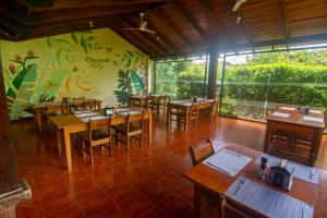 a restaurant with wooden tables and chairs and a mural at Rinconcito Lodge in Hacienda Santa María