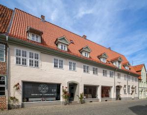 un gran edificio blanco con techo rojo en Johannis Suite - Schrangen-Suites-1389 en Lüneburg