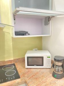 a microwave sitting on top of a counter in a kitchen at HATILLO SUITE in Caracas