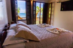 a bedroom with a bed with a view of the ocean at Pousada Ponta do Muta in Barra Grande