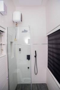 a shower with a glass door in a bathroom at Alder studio Apt+Gym+Snooker board. Rhodabode Nile in Abuja