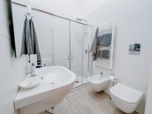 bagno bianco con lavandino e servizi igienici di a Casa di Gi' a Margherita di Savoia