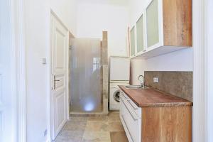 a kitchen with white cabinets and a sink at Beautiful apartment in 7th district in Budapest