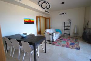 ein Wohnzimmer mit einem Tisch, Stühlen und einem Sofa in der Unterkunft Casalux One - Seaview - Outdoor Living - Pool - 5p in Pego