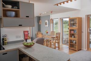 a kitchen and living room with a table and chairs at Cuillrigh - Luxury house, loch & mountain views in Portree