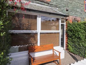een houten bank voor een raam bij Archers in Keswick