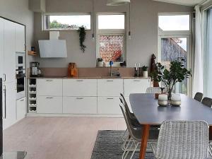 Holiday home SANKT IBB في Sankt Ibb: مطبخ مع دواليب بيضاء وطاولة مع كراسي