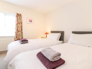 two white beds in a room with a window at Archers in Keswick