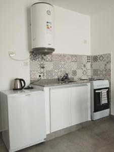 eine weiße Küche mit weißen Schränken und einer Mikrowelle in der Unterkunft Las Amapolas Jujuy in San Salvador de Jujuy