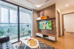 a living room with a couch and a tv at Sunny Vinhome Metropolis Apartment in Hanoi