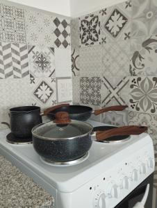 two pots and pans sitting on top of a stove at Las Amapolas Jujuy in San Salvador de Jujuy