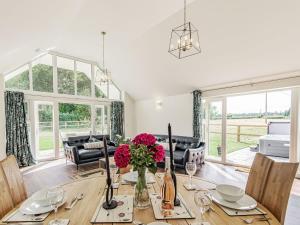 a dining room with a table with flowers on it at Kings Lodge in Neatishead