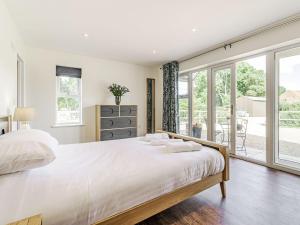 a bedroom with a large bed and a large window at Kings Lodge in Neatishead