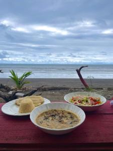 een tafel met twee borden eten op het strand bij El Retoño del Negro Gozón in Nuquí