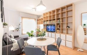 - un salon avec une table, des chaises et une télévision dans l'établissement MARIALUISA_PARK@HOME VFT/SE/03556, à Séville