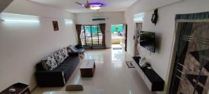 a living room with a couch and a tv at Kappys Villa in Igatpuri