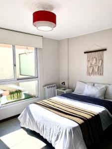 Un dormitorio con una cama grande y una ventana en Departamento céntrico, pileta cochera moderno y lujoso en Villa Carlos Paz