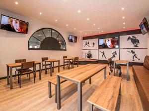 a restaurant with wooden tables and chairs and televisions at Sea View Lodge in Heysham