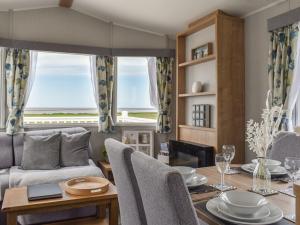 a dining room with a table and a couch at Sea View Lodge in Heysham