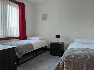 - une chambre avec 2 lits et une fenêtre dans l'établissement Lomond View Apartment, à Ladybank