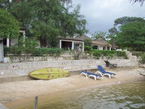 Mar Lodj的住宿－Bazouk Du Saloum Ecolodge，海滩上摆放着几把椅子和冲浪板