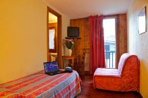 a woman standing in a bedroom next to a bed at Hotel Dolonne in Courmayeur