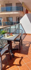 a glass table and chair on a balcony at Elegante alojamiento con piscina a 200 m del mar. in Benalmádena