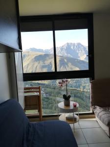 um quarto com uma grande janela com vista para uma montanha em Appartement au pied des pistes em Saint-Lary-Soulan