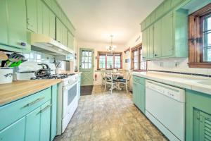 a large kitchen with green cabinets and a table at Private Waterfront Lake Erie Home with BBQ Patio in Saybrook