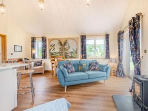 a living room with a blue couch and a table at Violet Cottage in Credenhill