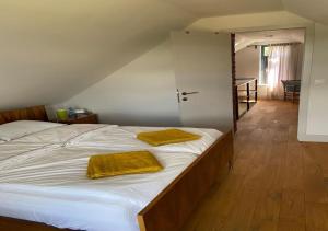 sypialnia z łóżkiem z dwoma żółtymi ręcznikami w obiekcie Dom wakacyjny Poniatówka w mieście Dąbrowa