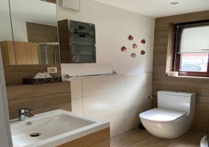 Łazienka z białą toaletą i umywalką w obiekcie Dom wakacyjny Poniatówka w mieście Dąbrowa