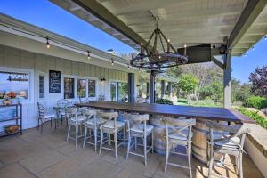 une terrasse avec une grande table et des chaises en bois dans l'établissement Peaceful Ranch Resort and Vineyard View, Pool Access, à Solvang