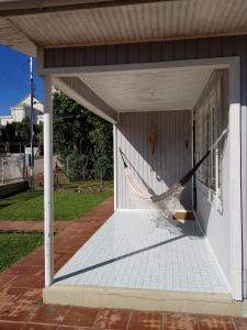 una hamaca en el porche de una casa en Casa Aurora en Cambara do Sul
