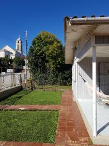 a side view of a white building with a yard at Casa Aurora in Cambara do Sul