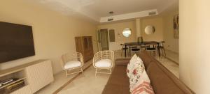 salon z kanapą, krzesłami i telewizorem w obiekcie LUMINOSO APARTAMENTO San Roque Golf Club w mieście San Roque