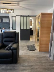 a living room with a couch and a glass door at T2 rénové, jaccuzi, sauna, sièges massants, jardin, parking, métro in Toulouse