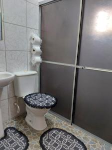a bathroom with a shower with a toilet and two rugs at Triunfo Flat in Triunfo