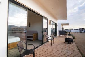 una terraza con sillas, una cama y un dormitorio en Finca San Sebastian, en Valle de Guadalupe