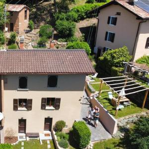 una vista aerea di una casa con persone in piedi nel cortile di Casa di vacanza in Capriasca ( Lugano ) a Bidogno