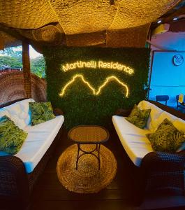 费尔南多 - 迪诺罗尼亚Martinelli Residence的标志前的两把椅子和一张桌子